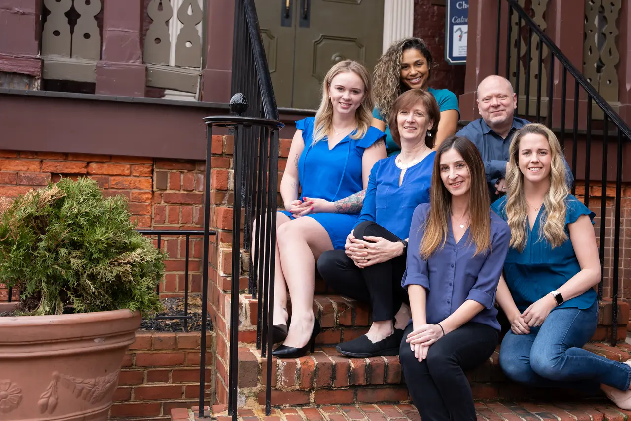 Patrick with the Chesapeake Think Tank team on the steps of a brick building.