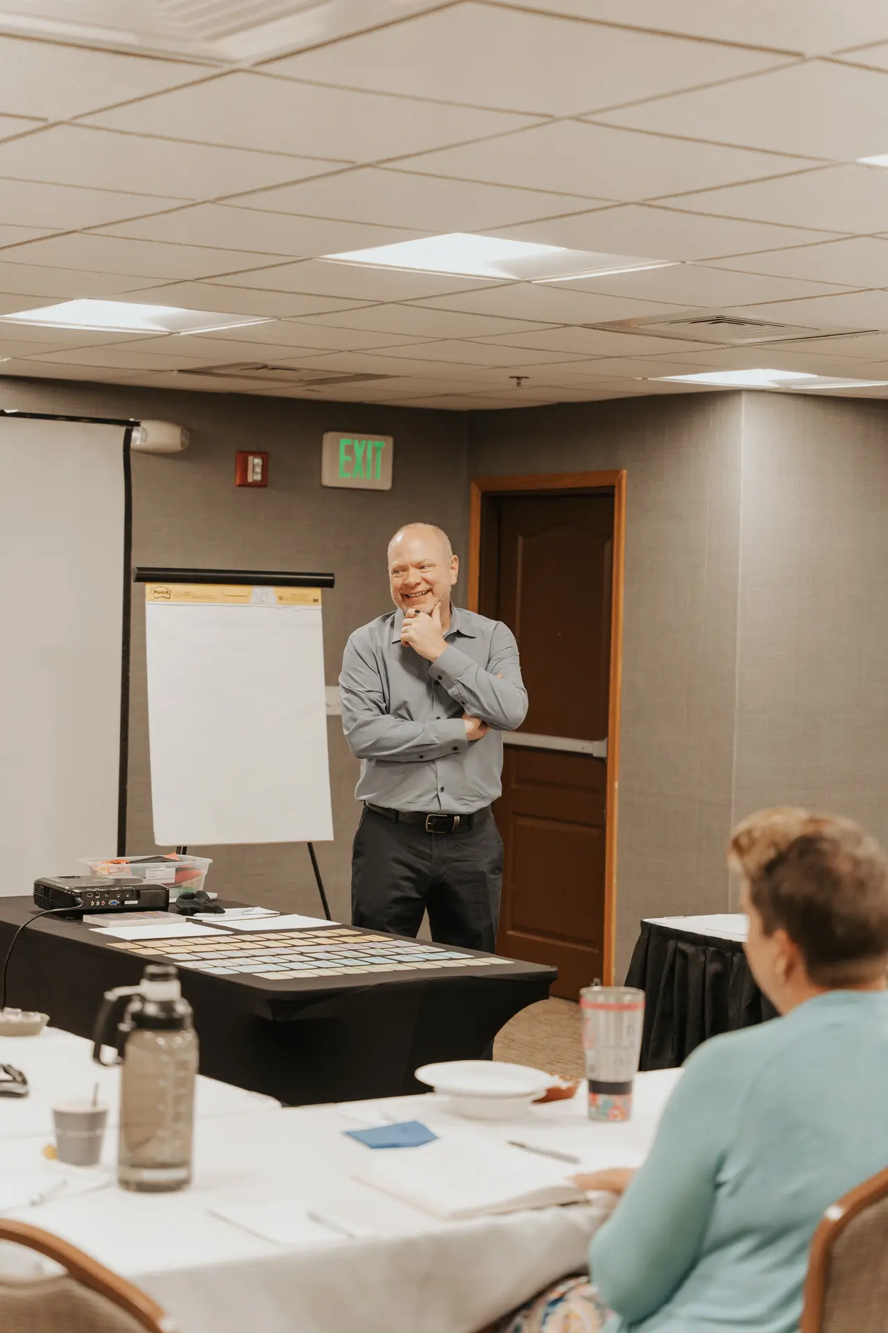 Patrick listening to a workshop participant beside a flipchart.